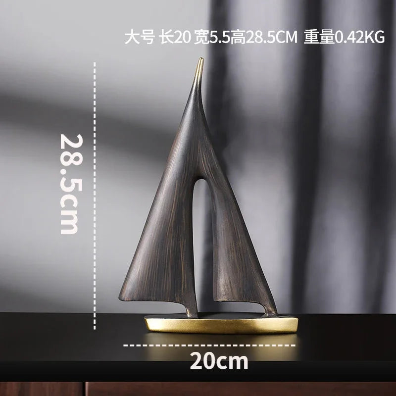 Modern minimalist resin sailboat ornament in a dark bronze finish with a gold-tone base.
