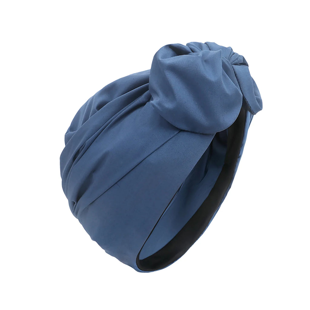 Blue vintage-style knotted turban hat with a smooth, matte finish and ruched detail.