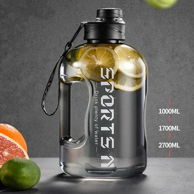 Large, clear grey sports water bottle with black lid, handle, capacity markers, and "SPORTS" text. Contains lemon.
