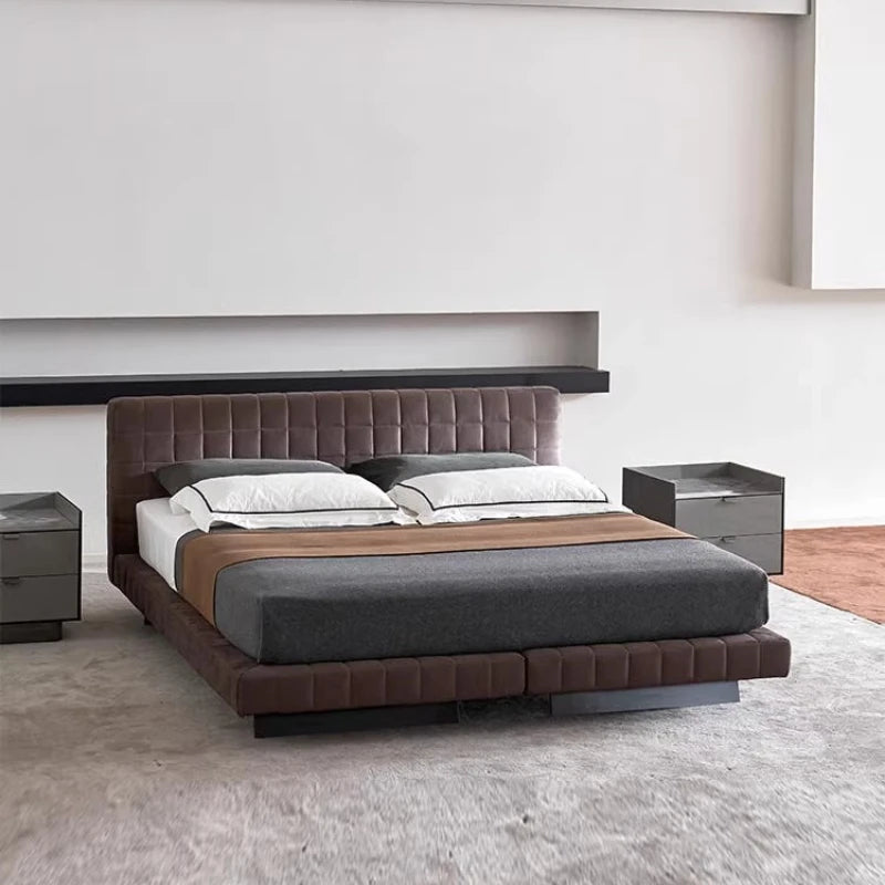 Modern Nordic-style chocolate brown upholstered bed frame with a panelled headboard and low-profile base.