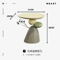 Minimalist cream-coloured side table featuring an artistic stacked pebble design base in neutral earth tones.
