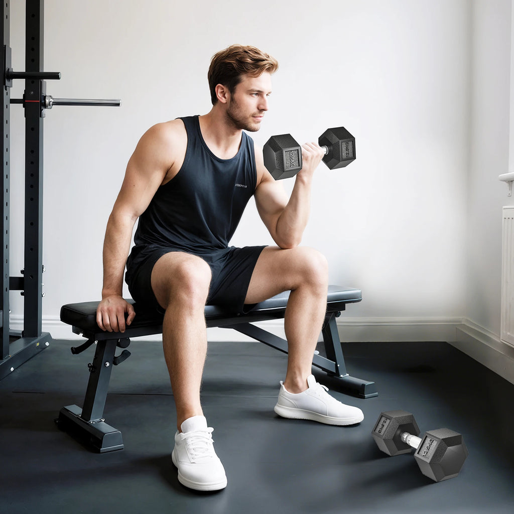 Man sitting on a gym bench curls a black 12.5kg rubber hex dumbbell, with a matching dumbbell on the floor.