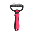 Pink and black pet grooming rake with stainless steel de-shedding blades and an ergonomic handle.