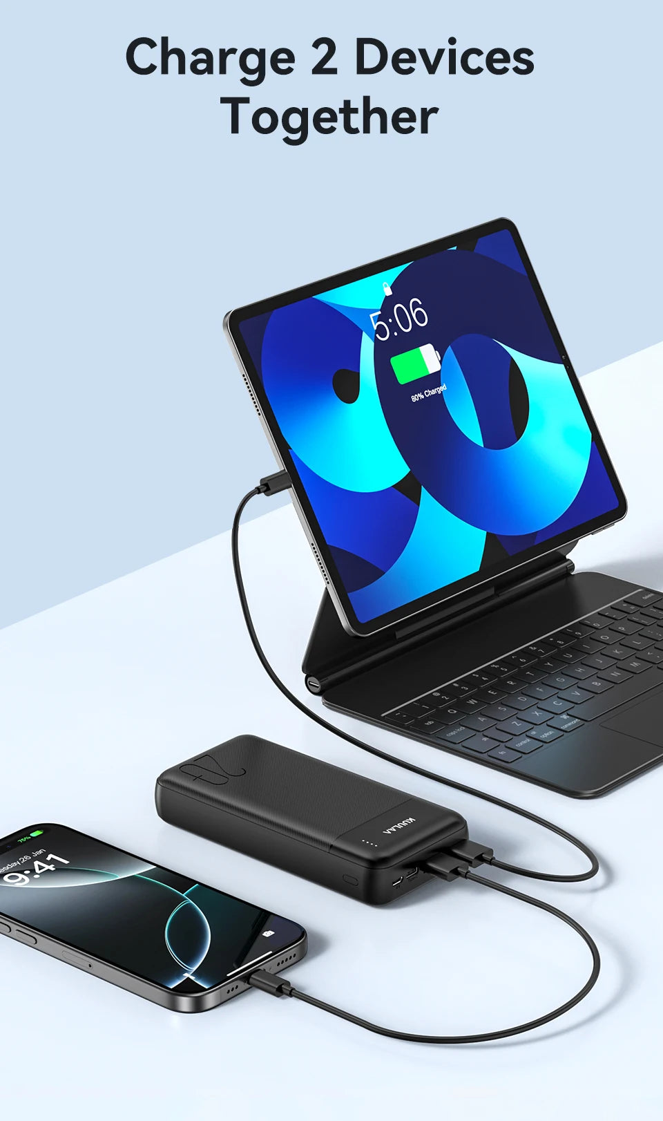 Black 20,000mAh portable power bank with LED indicator charging a tablet and smartphone simultaneously.