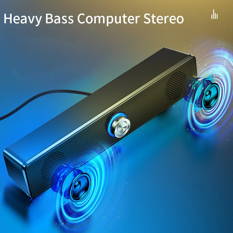 Sleek black USB computer soundbar with blue LED accent lighting, a central volume dial, and two exposed speaker cones.