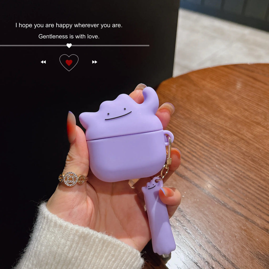 Purple silicone AirPods case featuring a cute, character-shaped design with a matching charm.