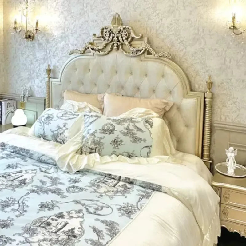 Ornate, cream-coloured Italian princess style double bed with a tufted headboard and decorative gold-toned detailing.