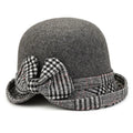 Grey felt winter bucket hat for women, featuring a decorative black and white houndstooth bow and trim.