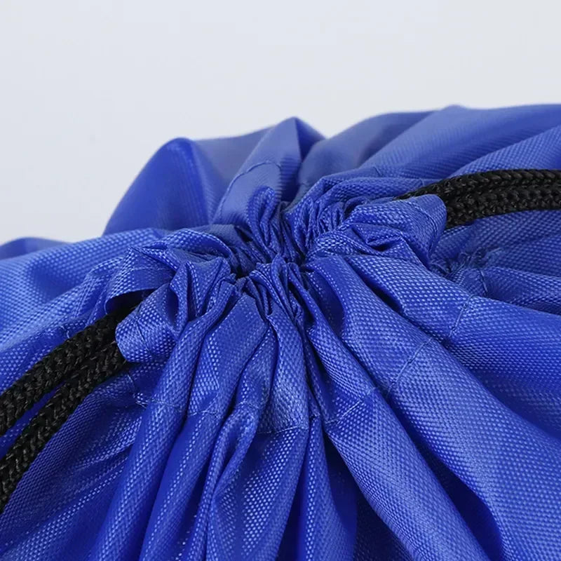 Close-up of a royal blue polyester drawstring bag with black cord ties cinched at the top.