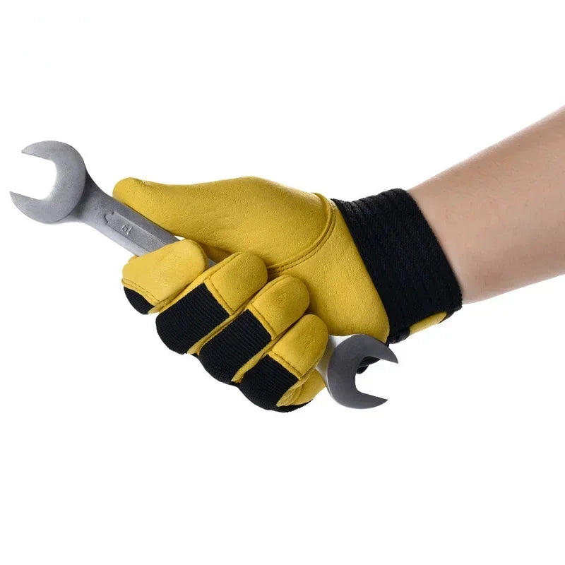 A hand wearing yellow and black cowhide leather work gloves, holding a metal spanner.
