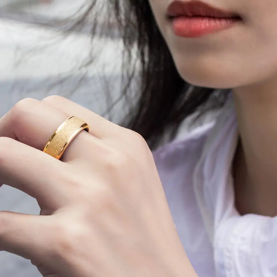 A sleek, gold-coloured smart health and sleep tracking ring worn on a finger, featuring a textured matte finish.