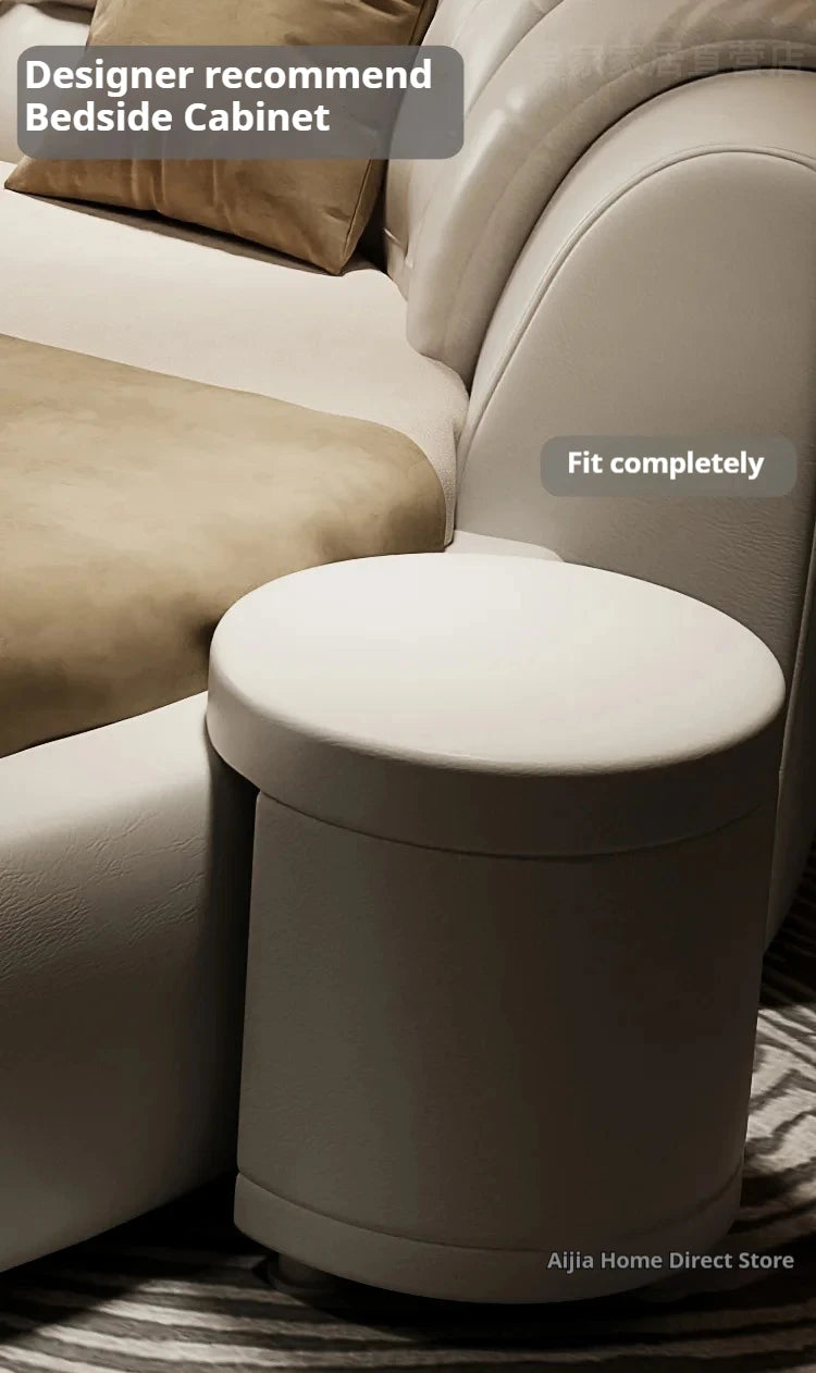 Modern cream-coloured round double bed featuring a minimalist leather-style finish and a matching integrated side table.