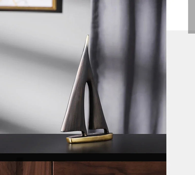 Elegant abstract resin sailboat ornament with a brushed bronze finish and a sleek gold-tone base.