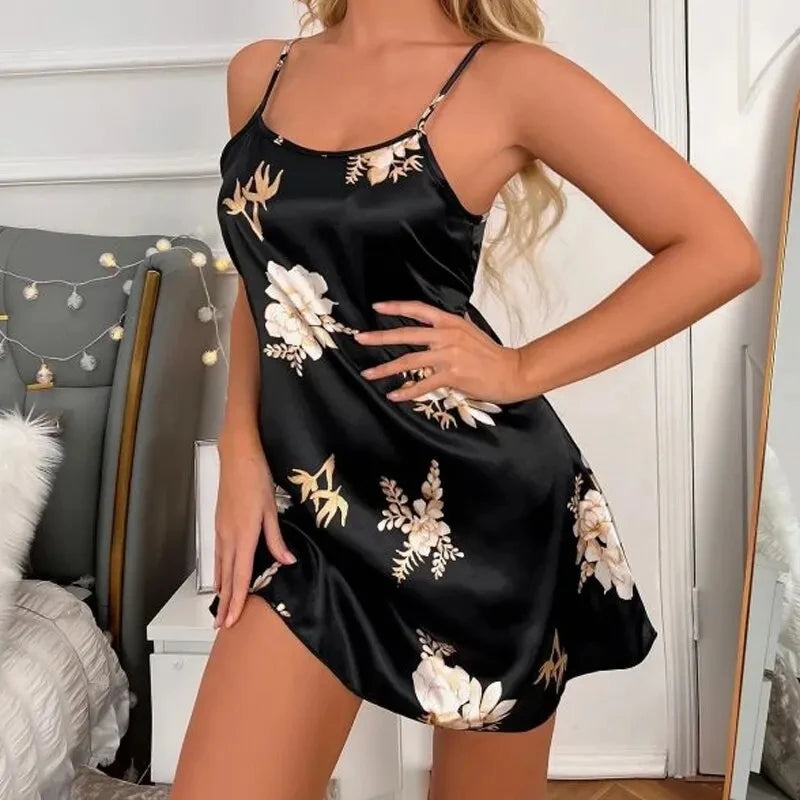 Black satin camisole nightdress with thin straps and a white and gold floral print, featuring a classic mini-length cut.