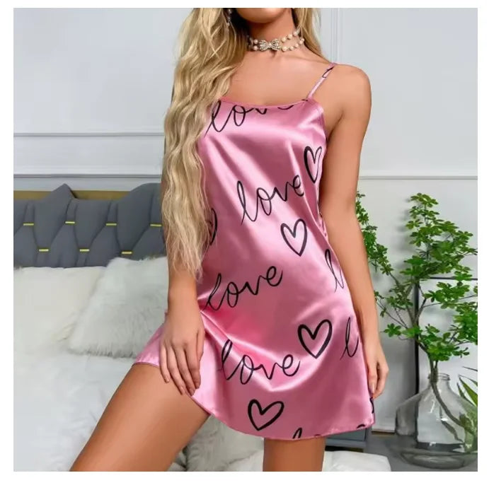 Pink satin camisole nightdress with black love hearts and text print, featuring thin spaghetti straps.