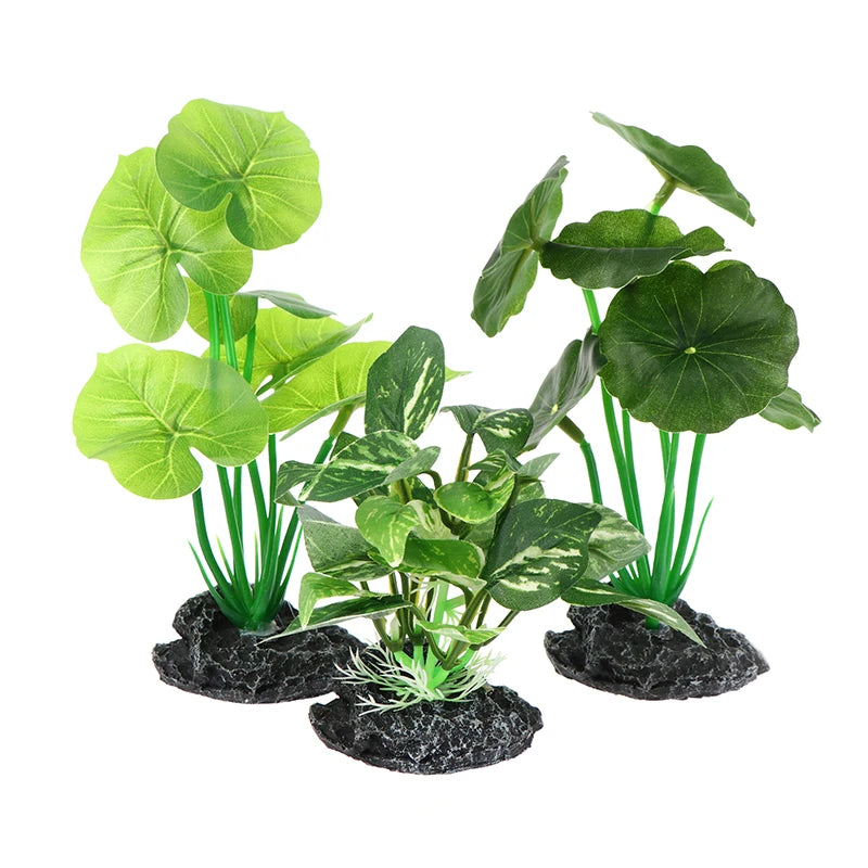 Three artificial aquarium plants with various green leaf shapes, sturdy stems, and textured black rock bases.