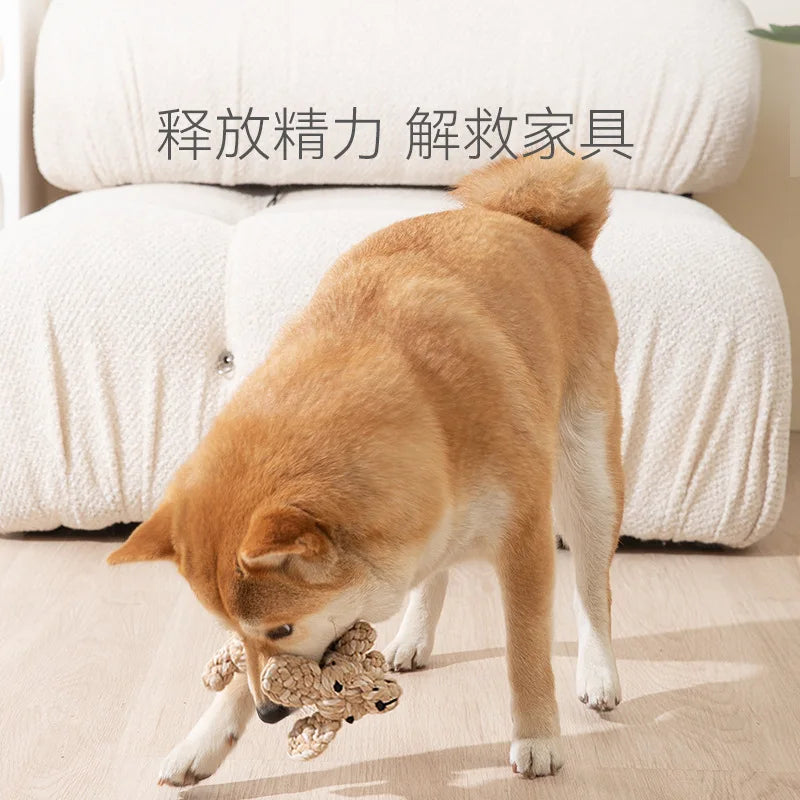 Shiba Inu dog playing with a tan, cartoon-style woven rope toy designed for teeth cleaning.