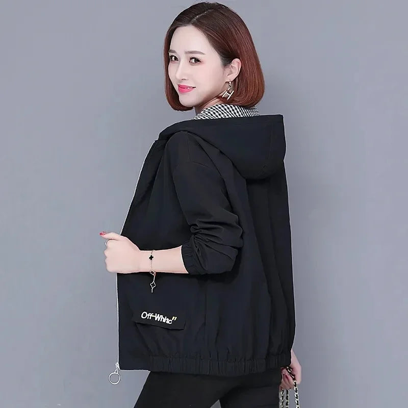 Woman wearing a black hooded zip-up jacket with a gingham collar and ribbed hem, shown from the side.