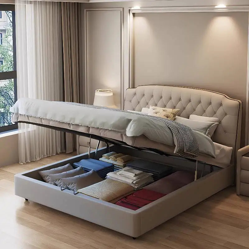 Luxury beige upholstered queen bed frame with button-tufted headboard and lift-up storage space filled with bedding.