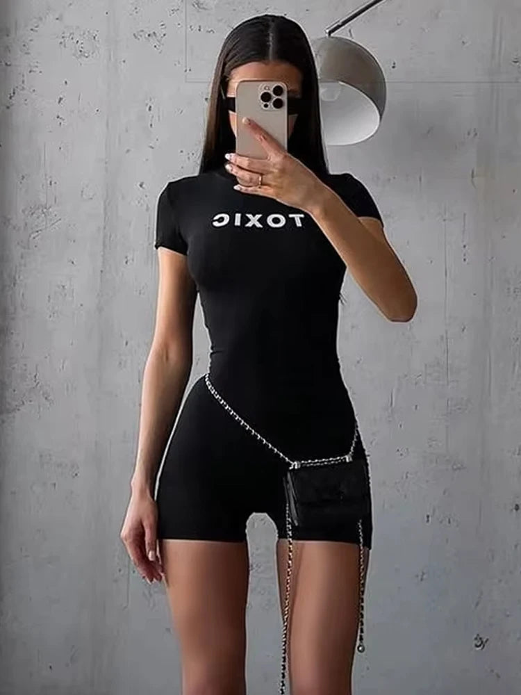 Form-fitting black romper with short sleeves, o-neck, and "TOXIC" printed in white across the chest.