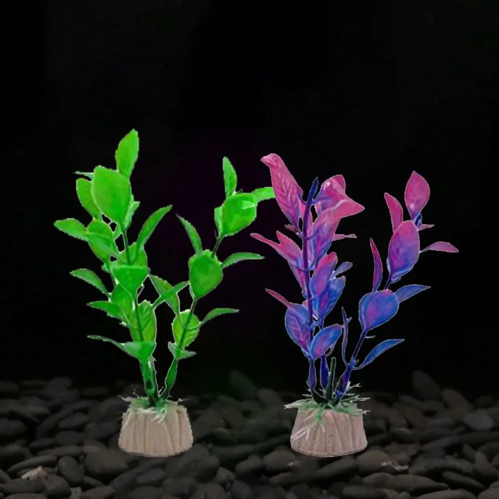 Two artificial aquarium plants with weighted bases: one bright green, the other purple-pink, set on dark gravel.