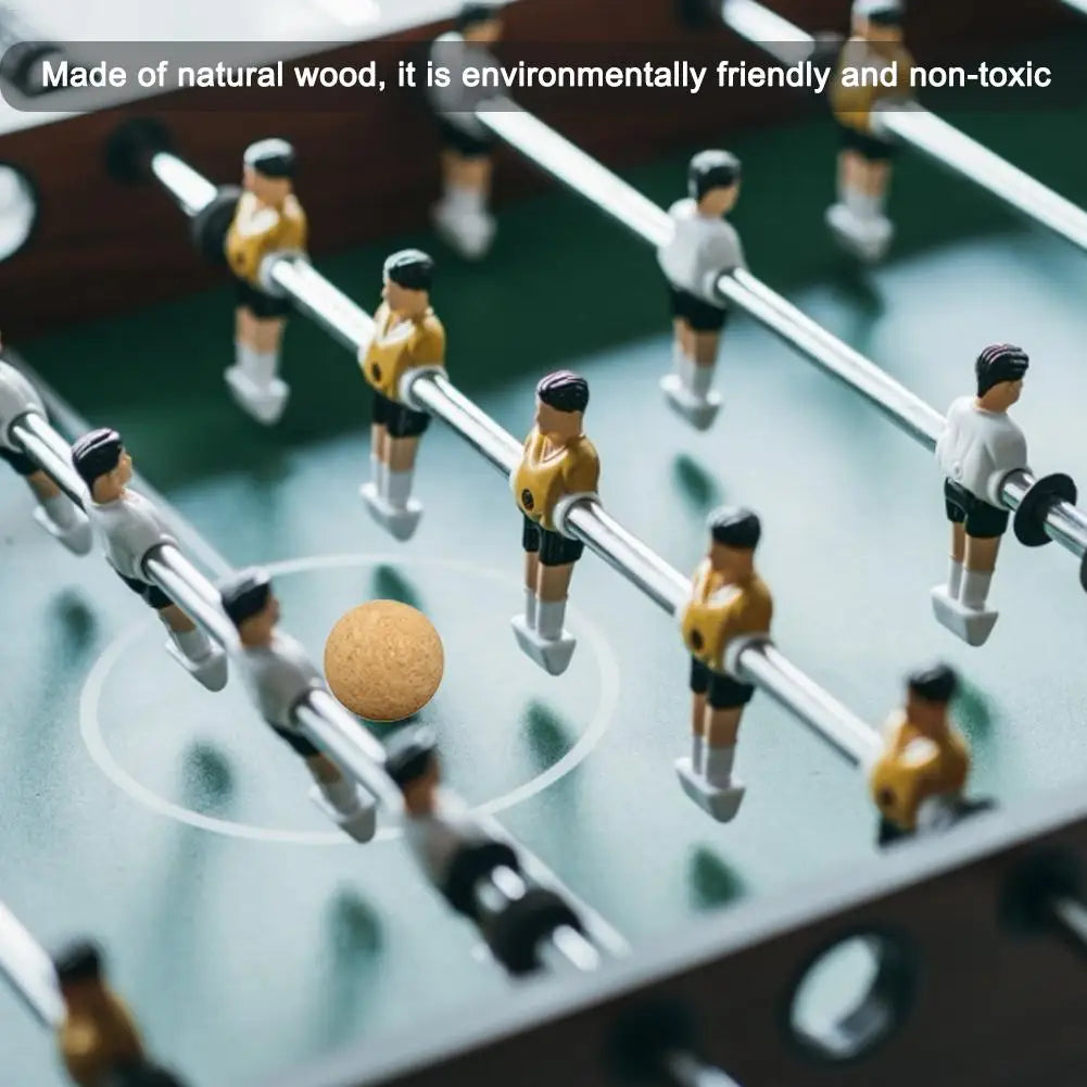Close-up of a natural wooden foosball table with yellow and white team players on metal rods.