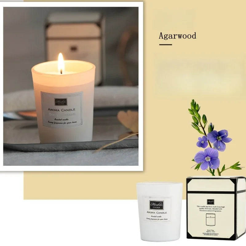 Agarwood scented candle in a white glass jar with minimalist label, shown lit and with its decorative gift box.