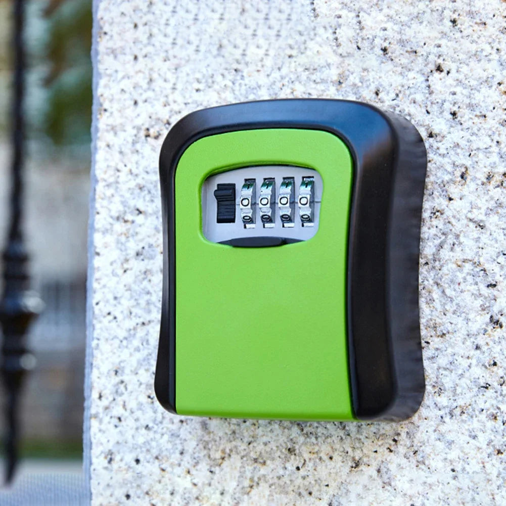 Green and black metal wall-mounted key lock box with a four-digit combination dial, attached to a stone surface.