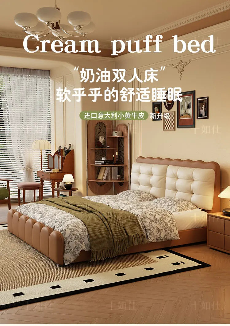 Modern cream and tan upholstered platform bed with a tufted headboard and scalloped edges in a bright bedroom.