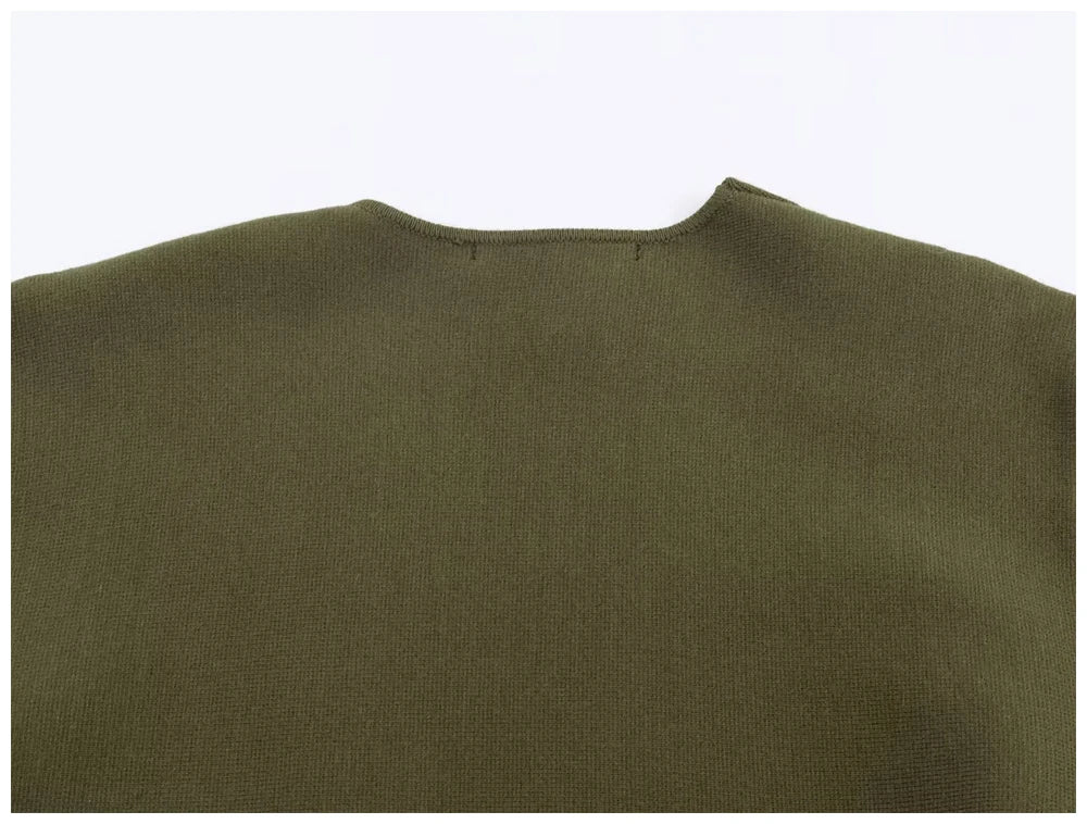 Close-up of an olive green knit jumper with a simple round neckline and fine-textured fabric.