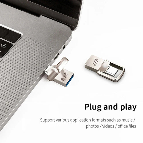 Sleek silver 2TB metal dual-connector flash drive plugged into a laptop, with a second unit shown beside it.