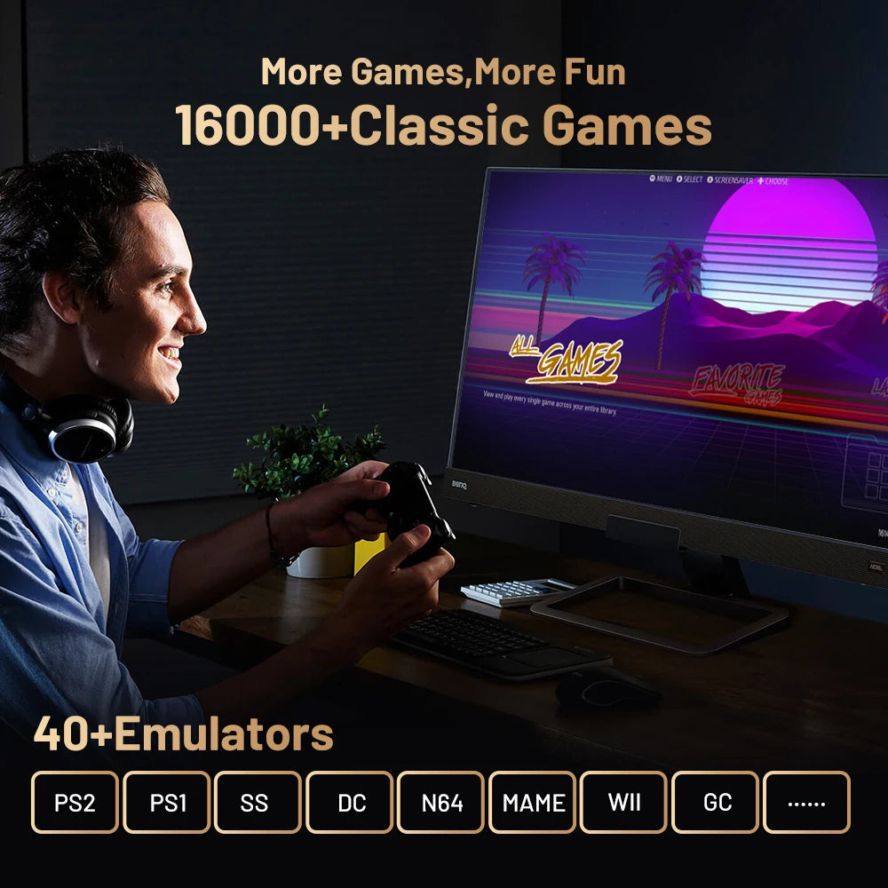 Smiling man holds a black retro game controller, playing a video game on a monitor displaying a colorful menu.