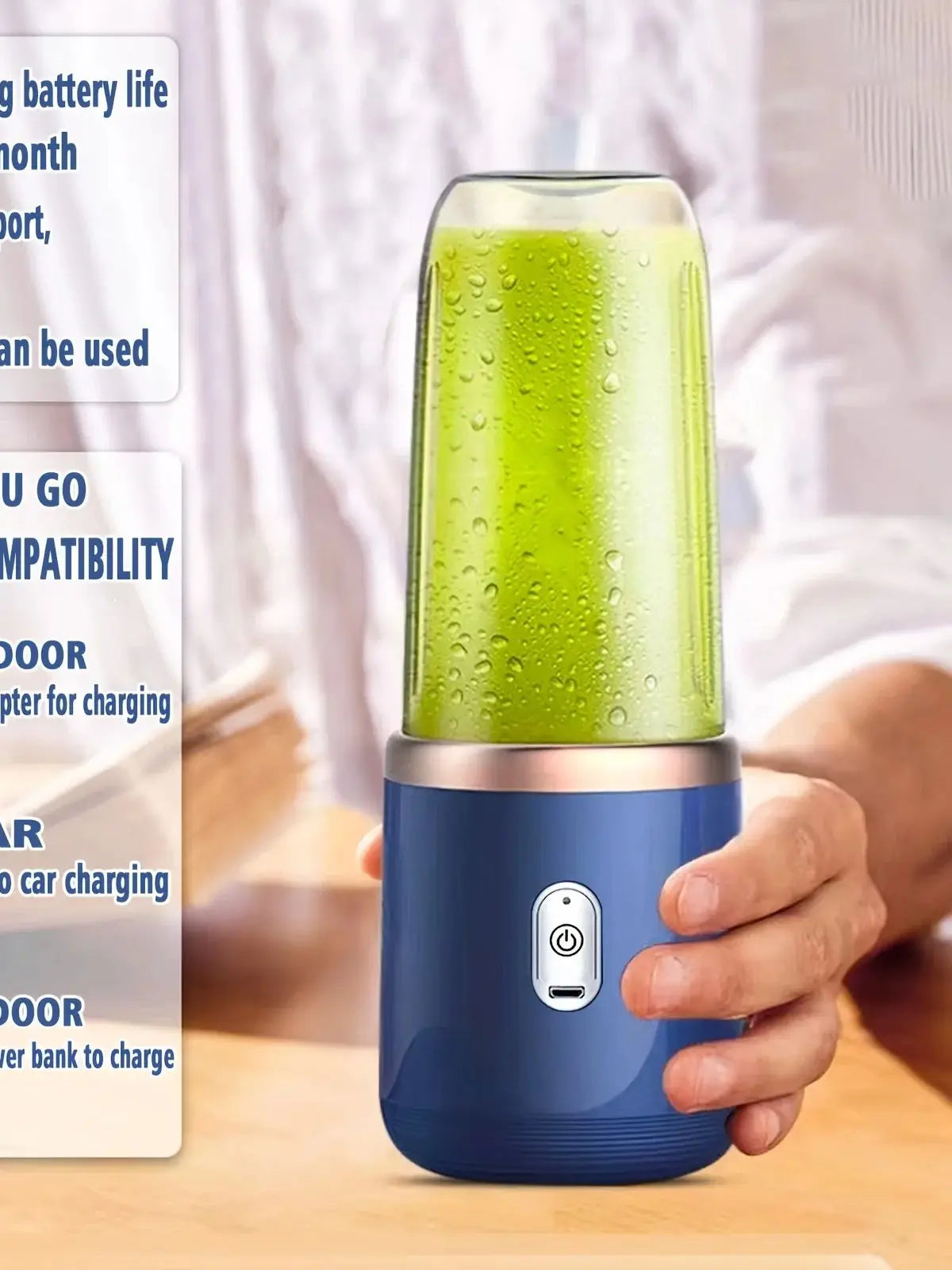 A hand holding a portable blue blender filled with a green smoothie, featuring a central power button and USB port.