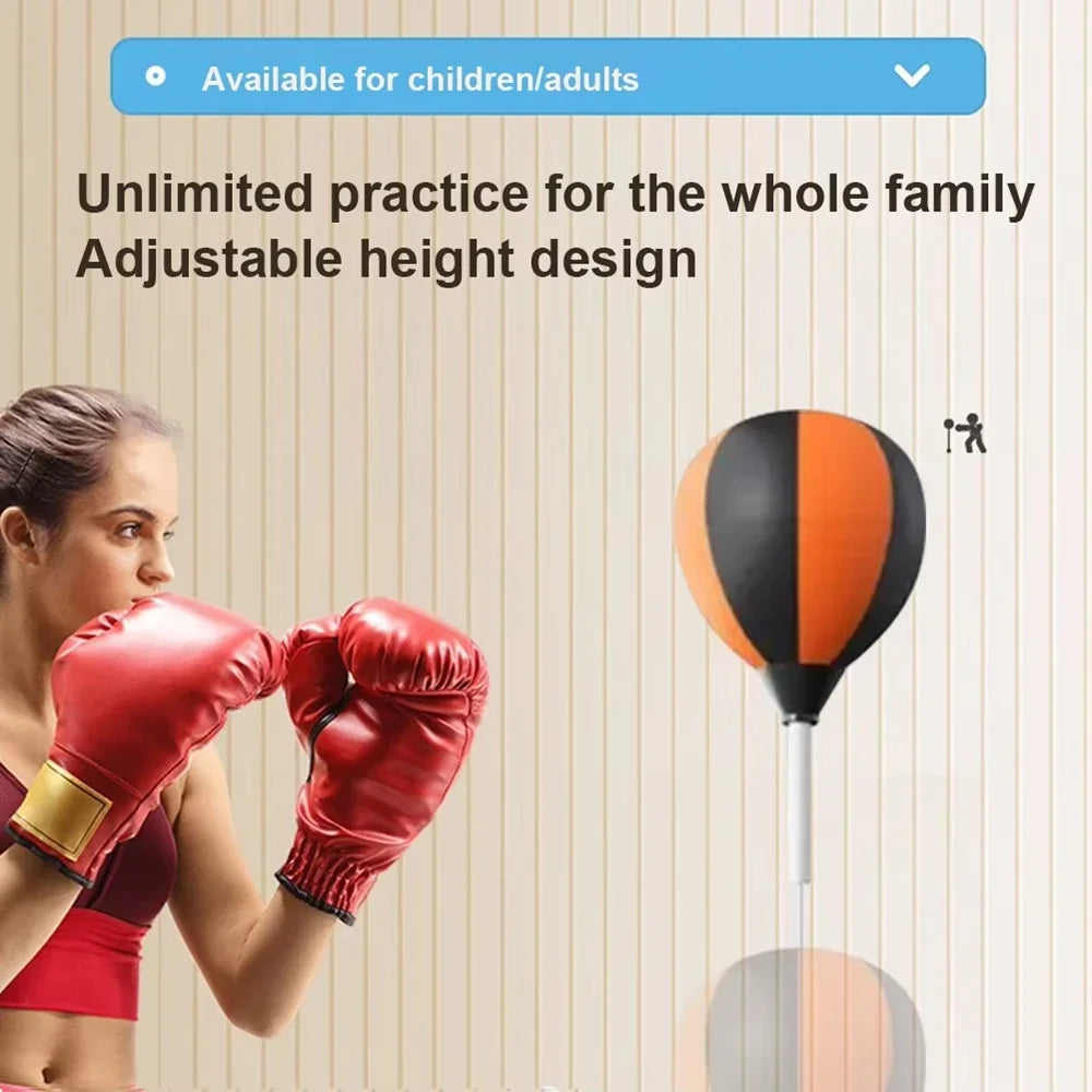 Black and orange speed bag on a stand next to a woman wearing red boxing gloves.