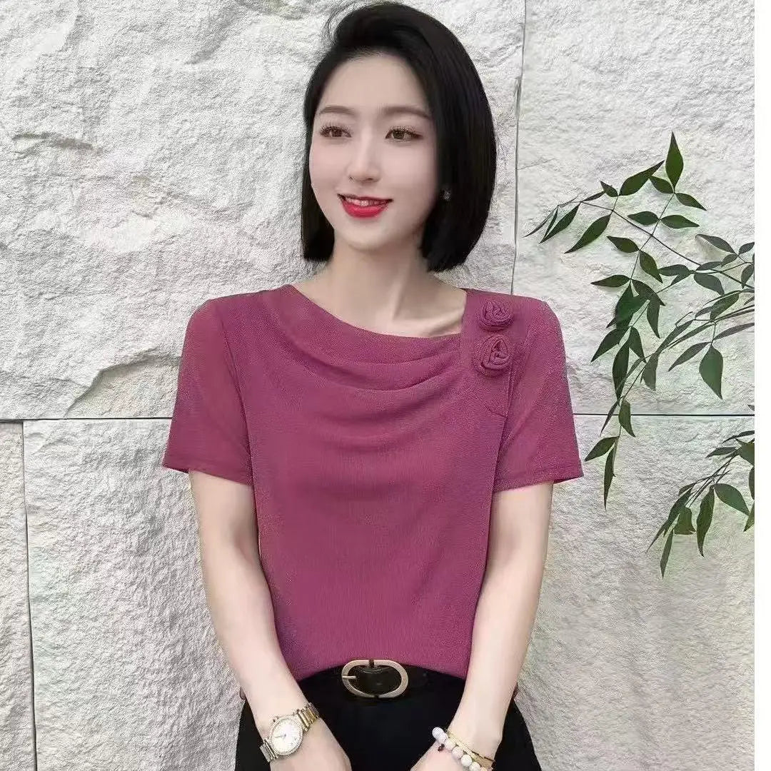 Women’s mauve short-sleeved blouse with draped neckline and floral shoulder detail.