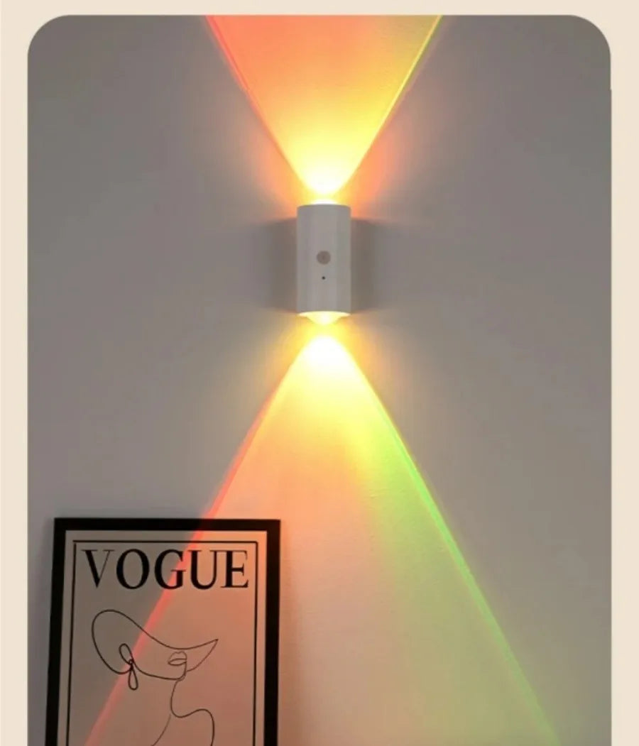 Minimalist white motion-sensor wall light casting a dual-beam sunset-gradient effect on a wall.
