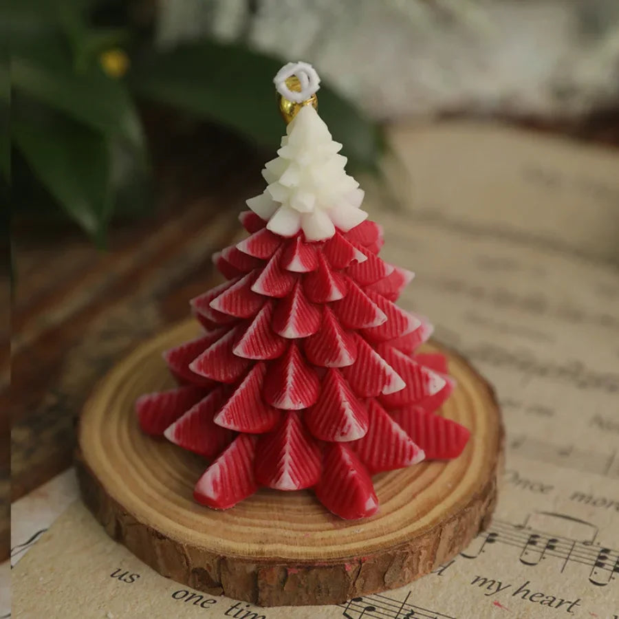 Red and white textured Christmas tree candle on a rustic wooden slice base, featuring a white star-shaped topper.