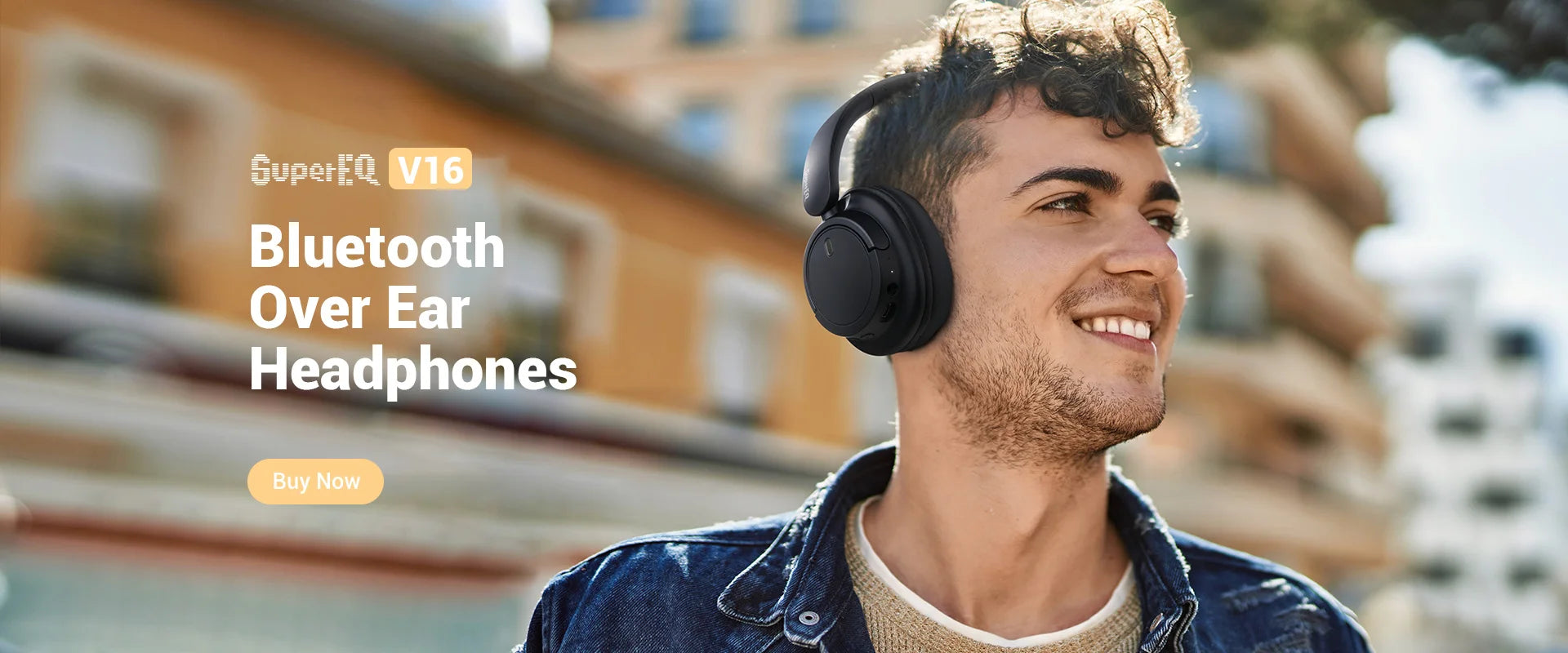 A young man wearing sleek, black over-ear studio headphones with a comfortable, modern design.