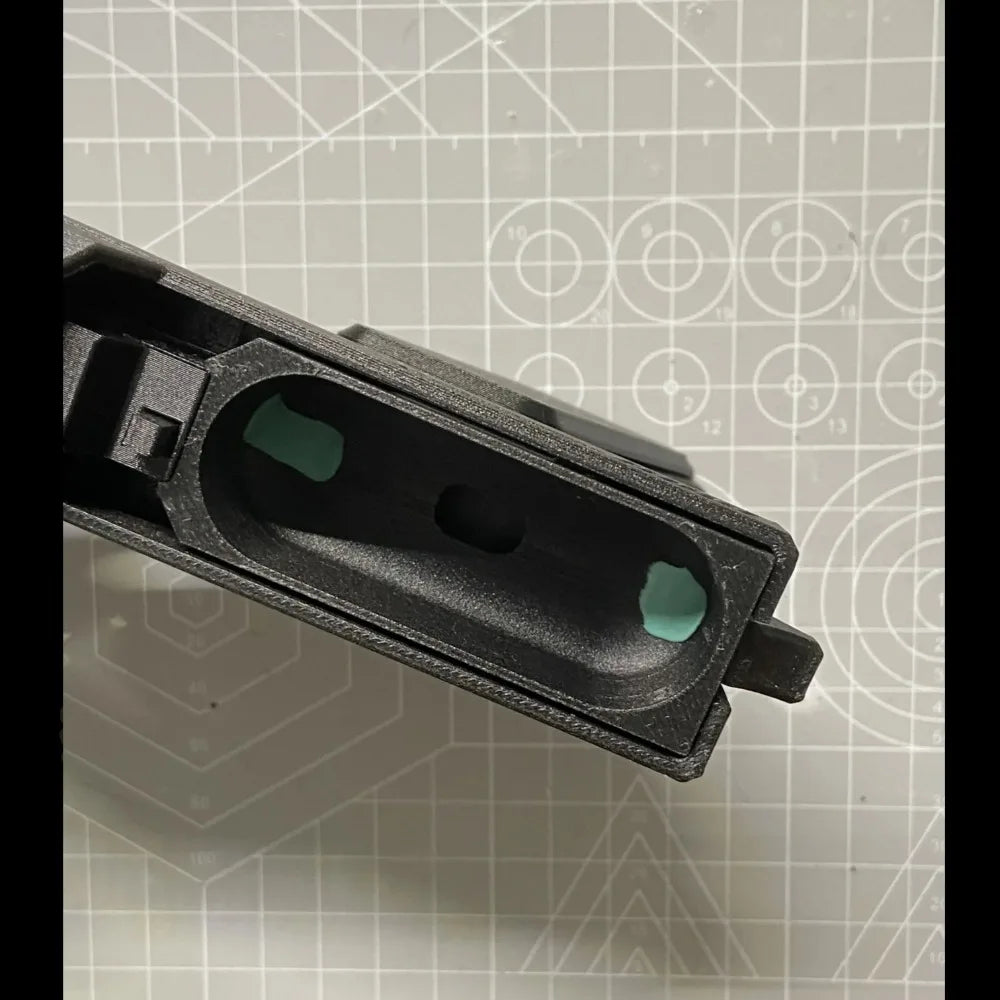 Black, textured 3D-printed AirPods case with internal teal padding. Close-up view of the empty charging compartment.