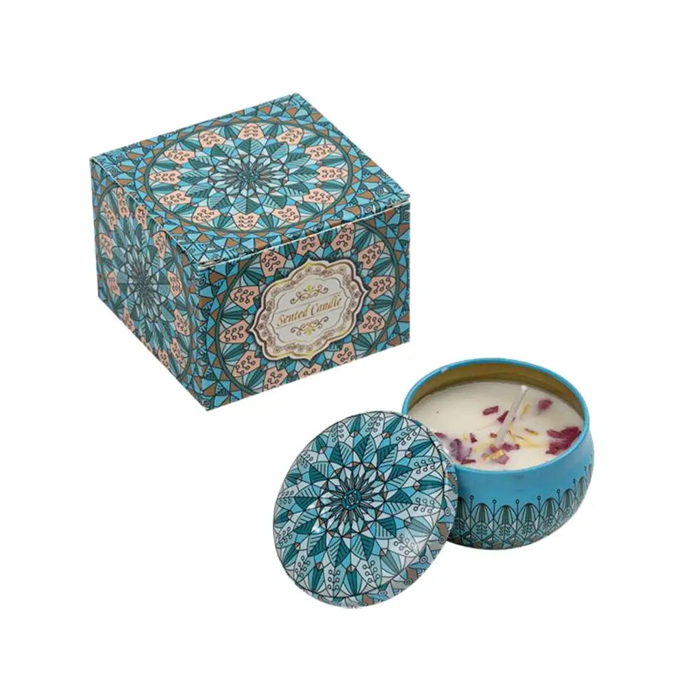 Scented candle in a blue patterned tin with a matching decorative box, featuring botanical petals on the wax surface.