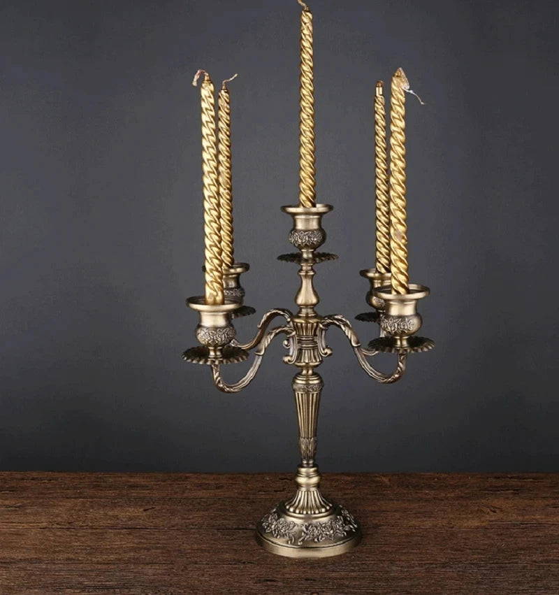 Bronze metal 5-arm candelabra featuring ornate floral engravings holding five twisted gold candles.