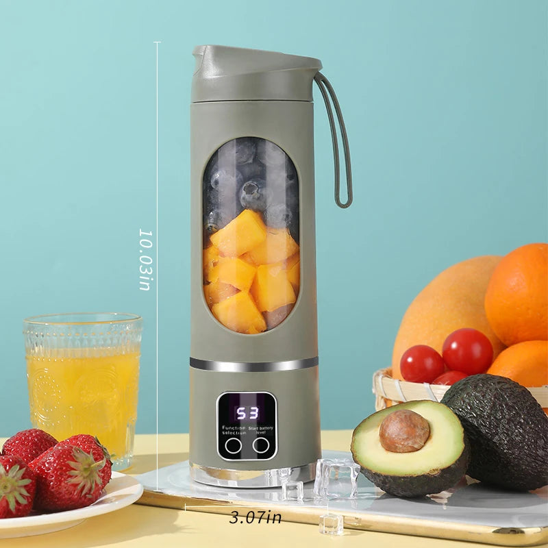 Olive green portable blender with digital battery display, containing mango and blueberries, surrounded by fresh fruit.