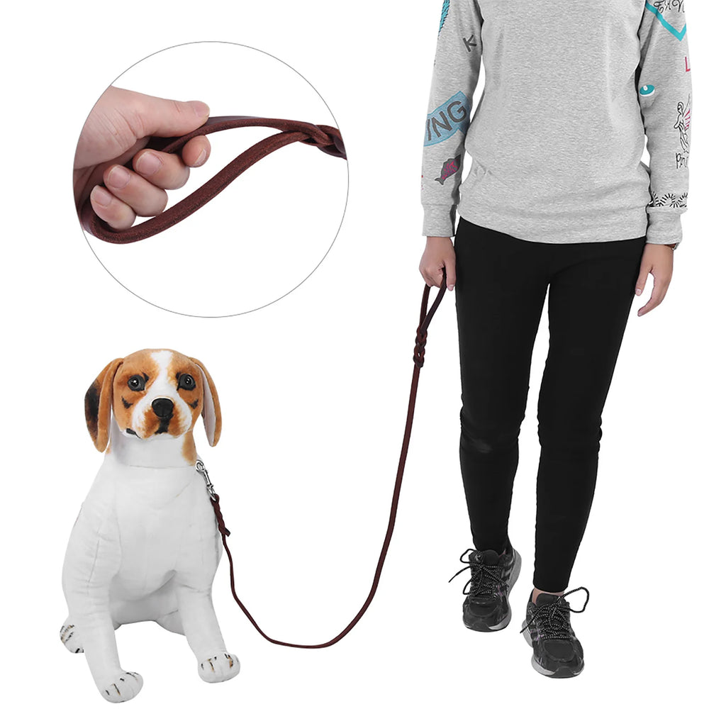 A person holds a dark brown, slim leather dog lead attached to a toy beagle, featuring a comfortable looped handle.