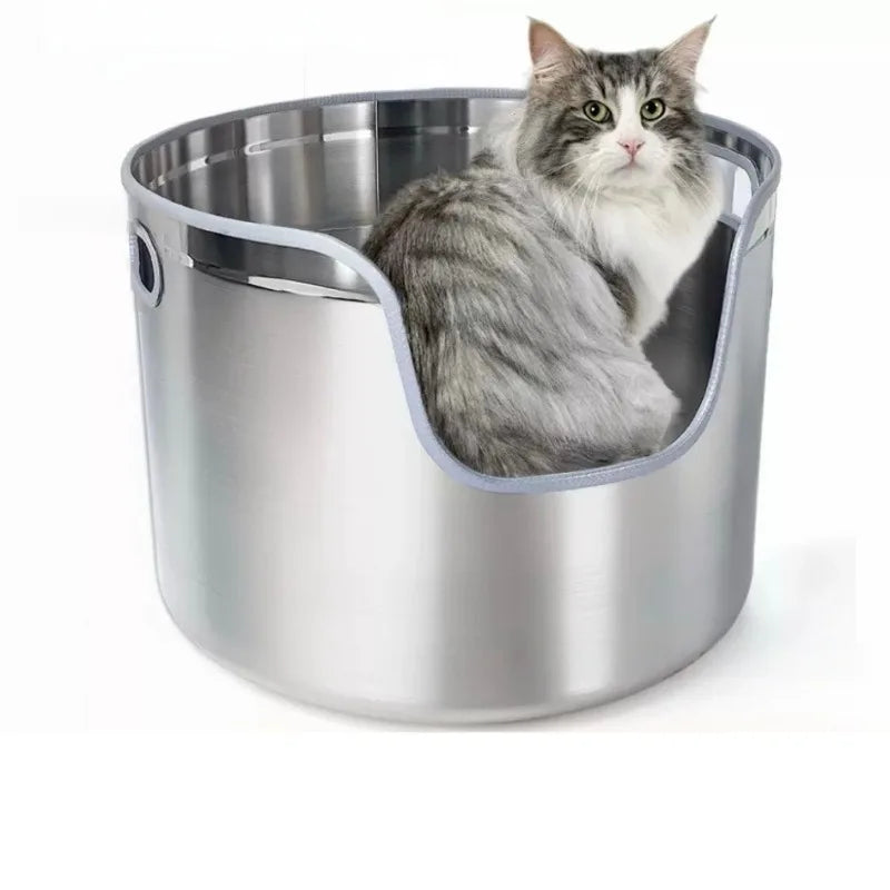Round silver stainless steel cat litter box with a low front entry, holding a fluffy gray and white cat.