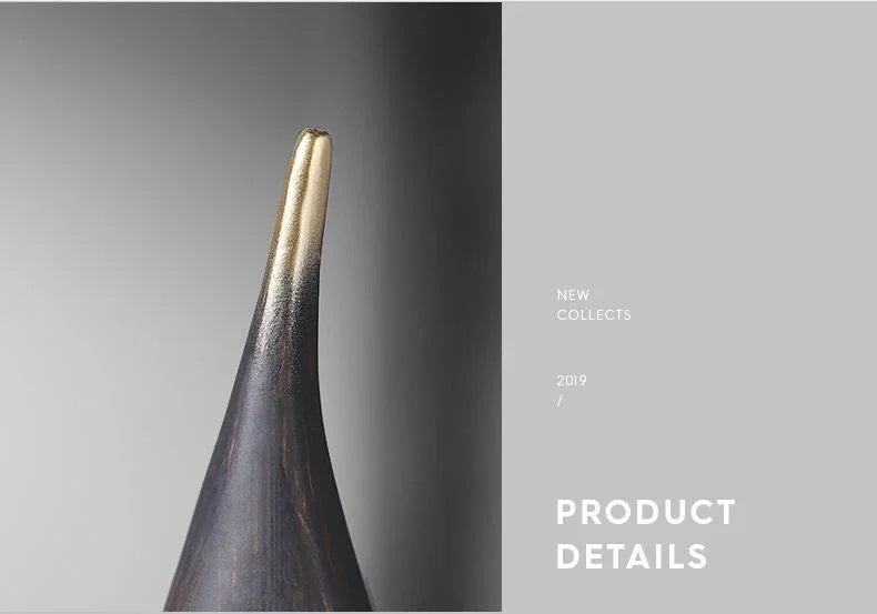 Minimalist resin sailboat ornament in a dark wood finish with a sleek, gold-dipped tapered tip.