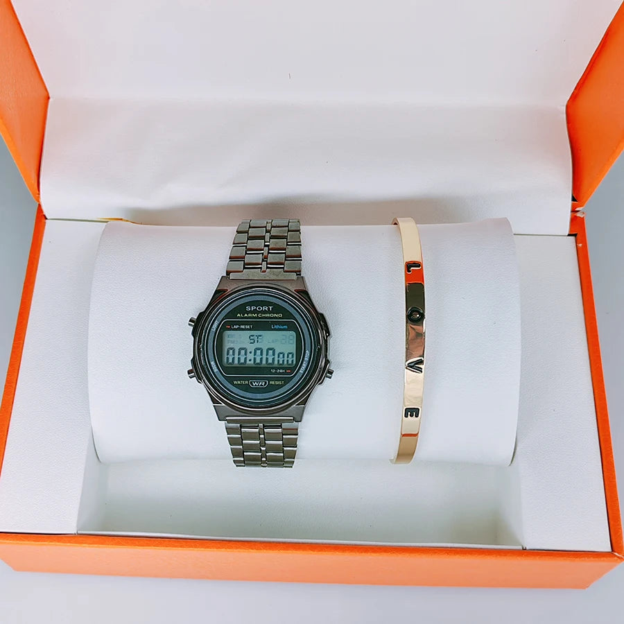A retro-style silver-tone digital watch and a gold-tone "LOVE" bangle set displayed in an open orange gift box.