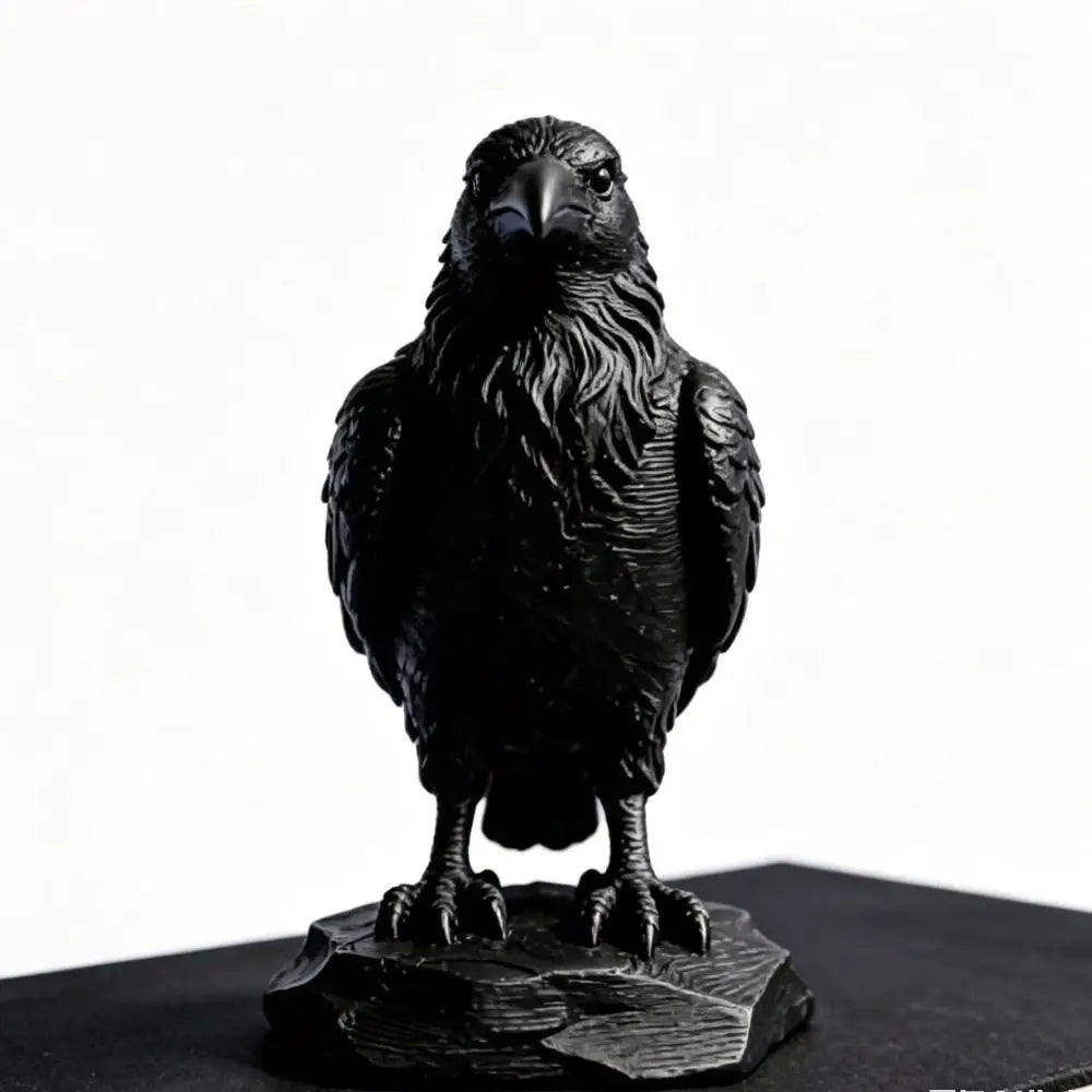 Detailed matte black raven sculpture standing on a textured rock base, featuring intricate feather detail.