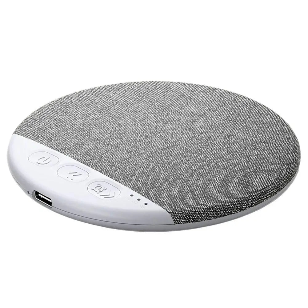 Round, grey fabric-topped wireless under-pillow Bluetooth speaker with white control buttons and a charging port.