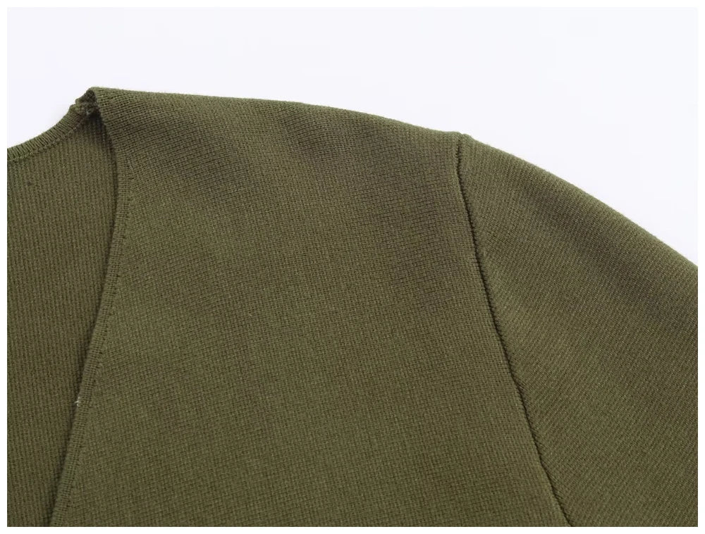 Close-up of a khaki green knit top featuring a round neckline and structured shoulder seams.