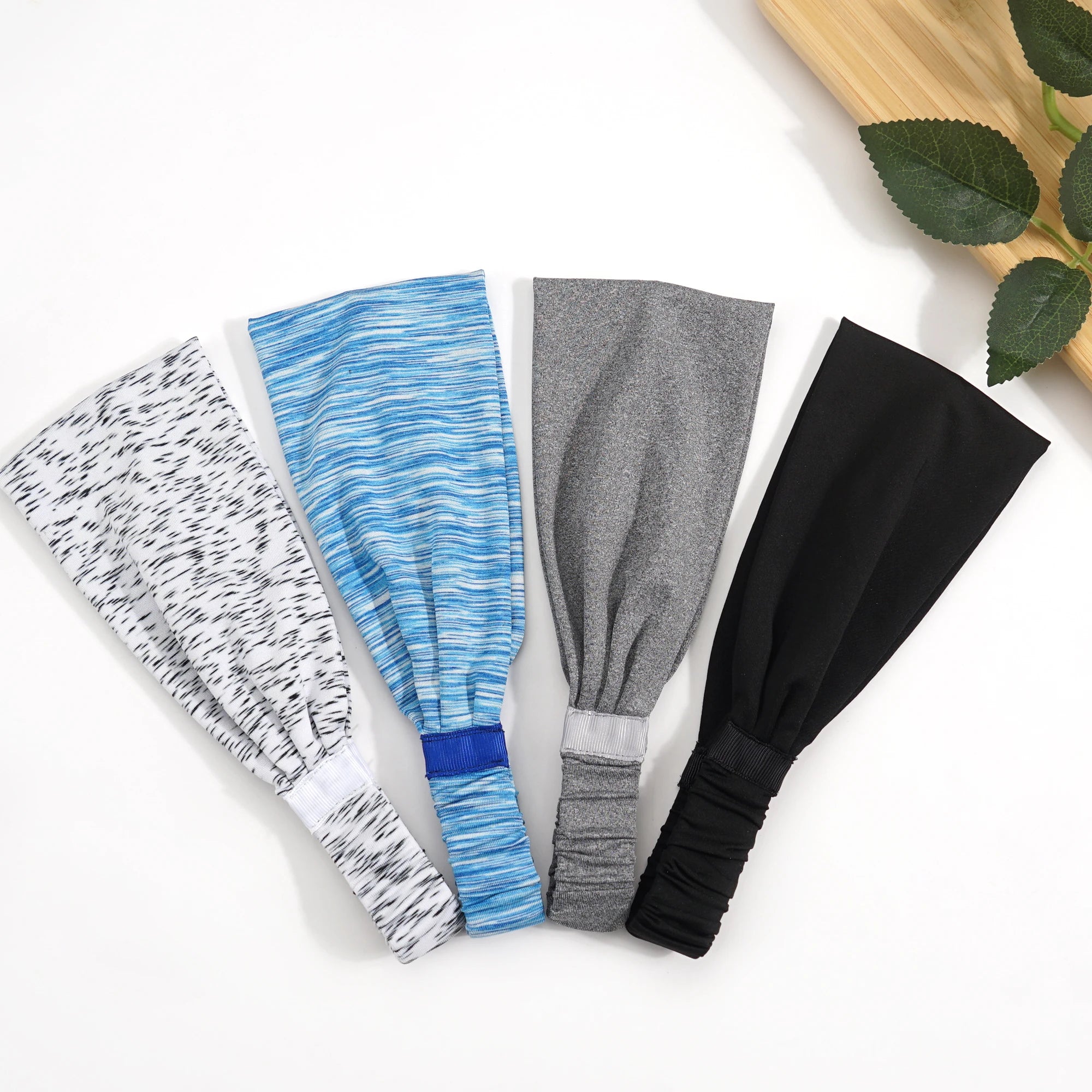 Four stretchy sports headbands in white marl, blue space-dye, grey marl, and solid black.